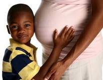 Boy Holding Pregnant Mother's Stomach at Pediatric Dentist Office in Clarks Summit